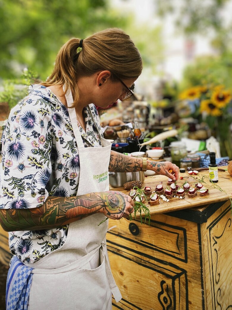 Food-Influencerin Tanja Kirmse steht an einem Tresen und richtet kleine Sandwiches auf einem Teller an